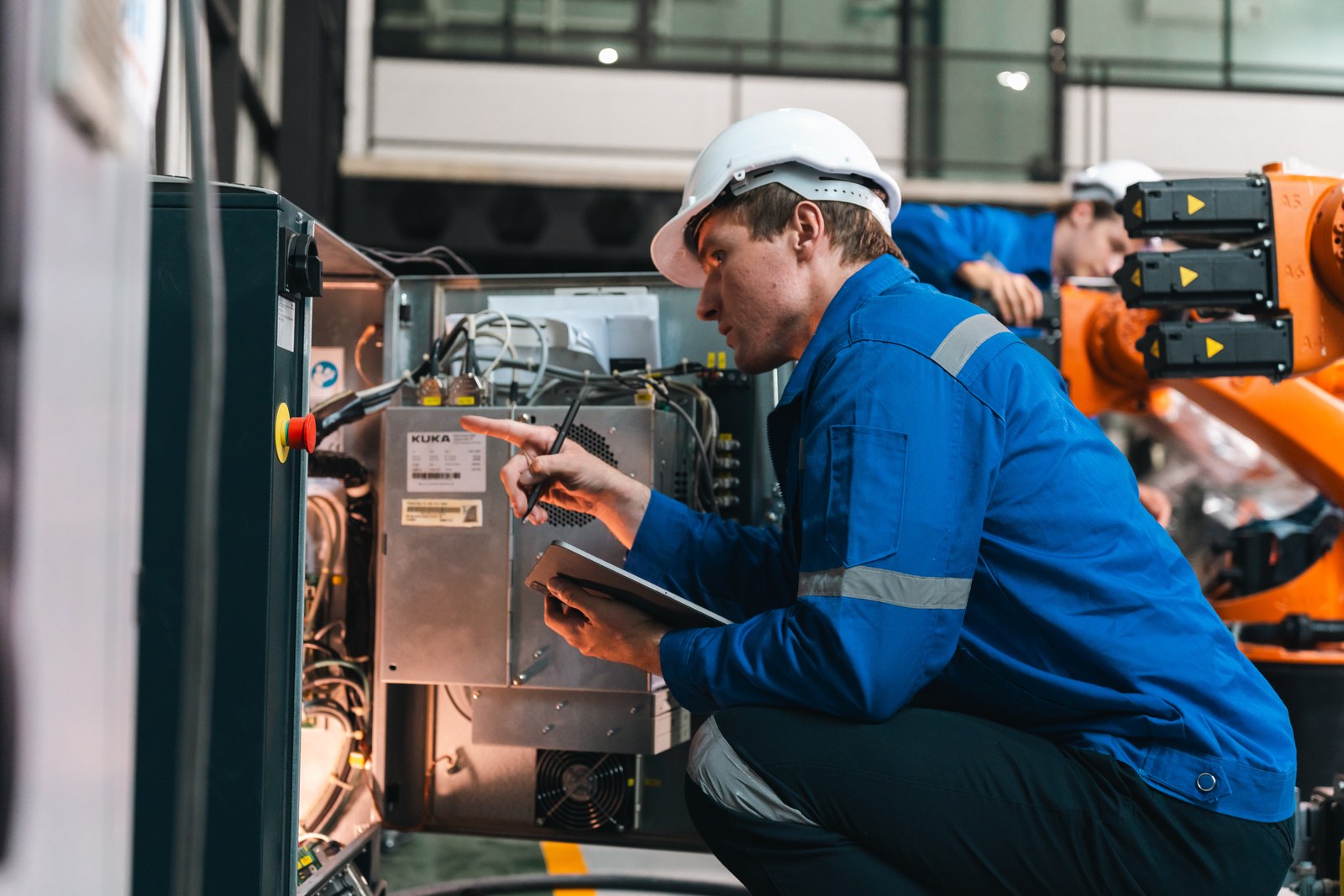 Technician inspecting an industrial machine control cabinet